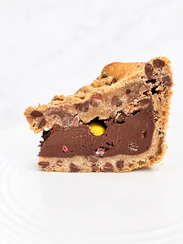 A slice of chocolate cake with chocolate chips and a yellow center.