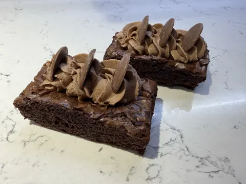 Two chocolate cakes with chocolate frosting and chocolate sprinkles.