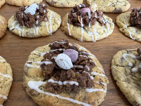 A plate of cookies with white icing and marshmallows on top.