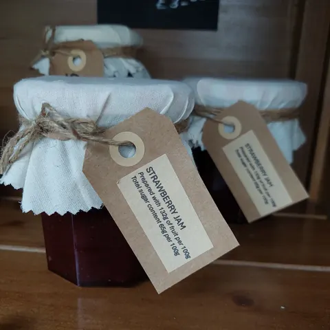 A jar of strawberry jam with a tag on it.