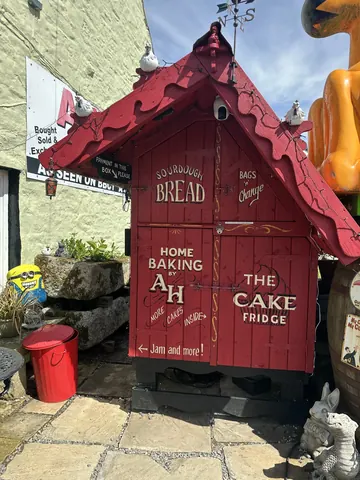 A red building with a sign that says "The Cake Hedge".