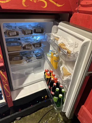A refrigerator with a bottle of soda in it.