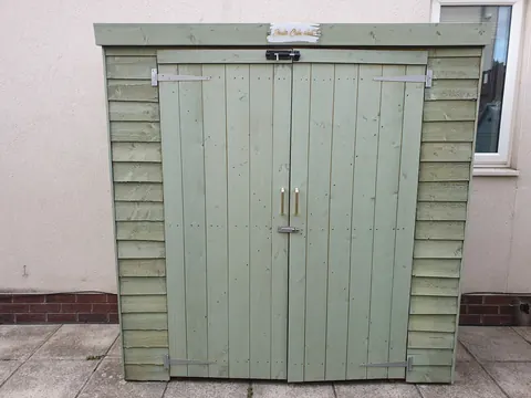A green door with a sign on it.