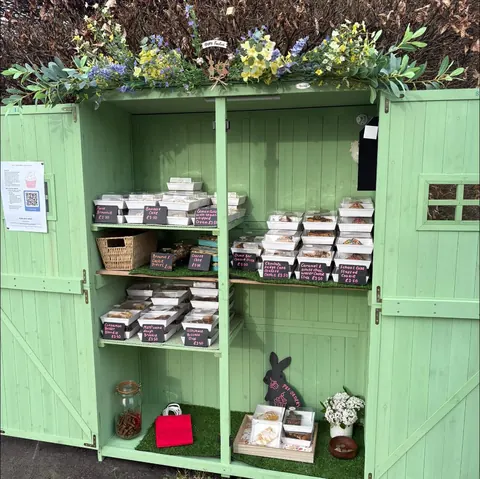 A green shed with a sign that says "welcome to the rabbit hole".