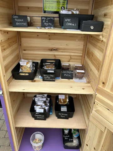 A wooden shelf with a variety of food items on it.