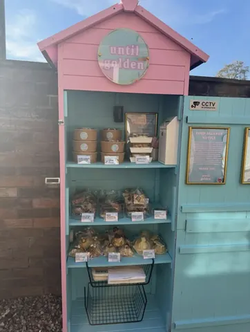 A pink and blue building with a sign that says "untill golden".