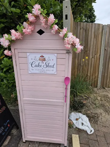 A pink shed with a sign that says "cake shack" on it.