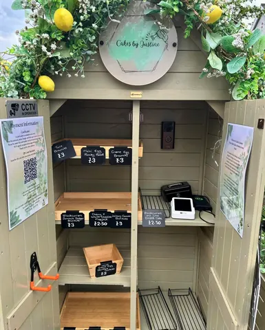A small wooden building with a sign that says "Cakes by Silhouette".