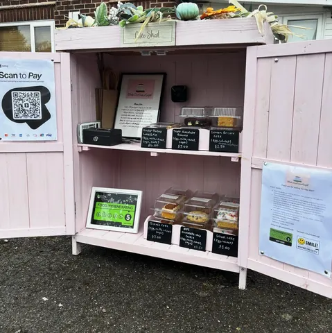 A pink wooden structure with a sign that says "scan to pay" on it.
