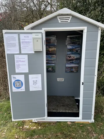 A small grey shed with a white door.