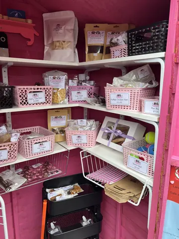 A pink room with a shelf full of food.