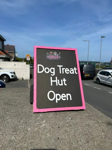 A sign that says Dog Treat Hut Open.