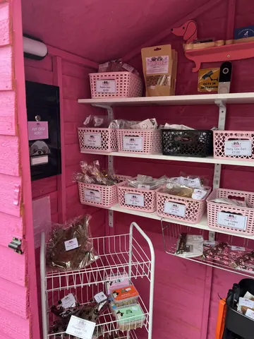 A pink building with a white shelf inside.