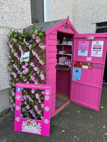 A pink building with a sign that says "open" on it.