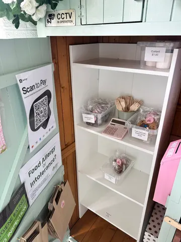A white shelf with a sign that says scan to pay.