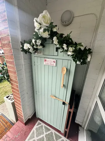 A blue door with a white wreath on it.
