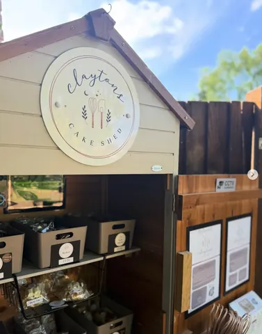 A small wooden building with a sign that says "Crystals Cake Shed" on it.