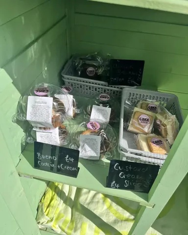 A display of various desserts in a green case.