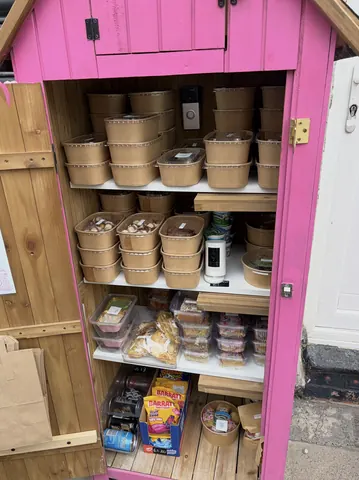 A pink cabinet with a white shelf inside.