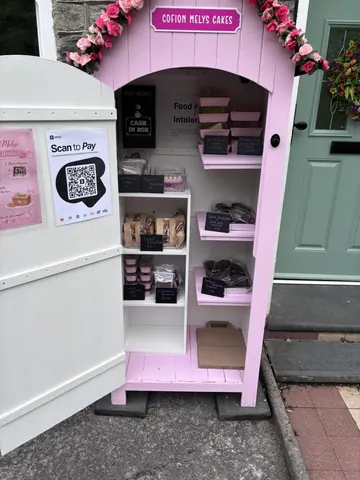 A pink food cart with a sign that says scan to pay.