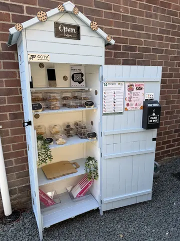 A blue and white food stand with a sign that says "Pizza".