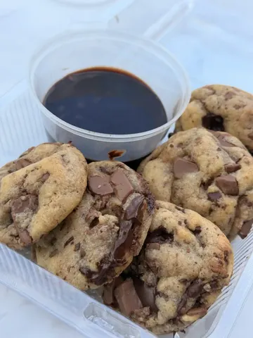 A bowl of chocolate sauce with cookies in it.
