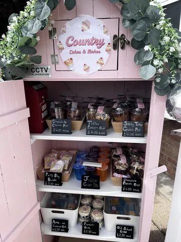 A pink cabinet with a sign that says Country Cakes & Bakes.
