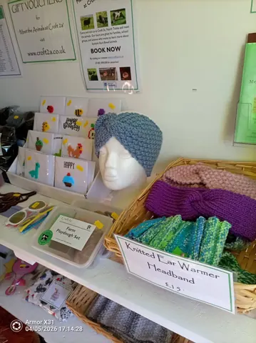A display of knitted items, including a knitted hat, is on a table.