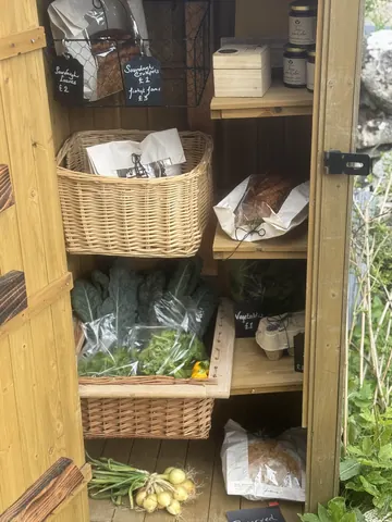 A wooden shelf with a basket of vegetables on it.