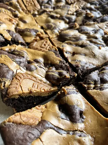 A slice of chocolate cake with a cookie on top.