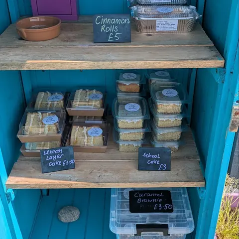 A blue shelf with a sign that says "cinnamon rolls" on it.