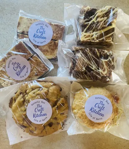 A variety of baked goods are displayed in plastic bags.