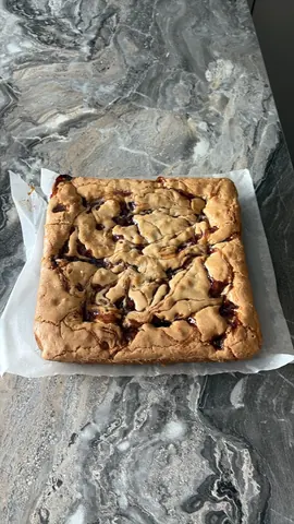 A square piece of cake on a paper towel.
