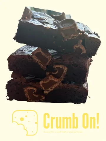 A stack of brownies with chocolate chips on top.