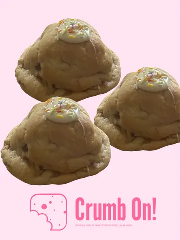 Three cookies with white frosting and sprinkles on top.