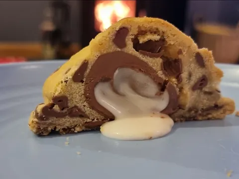 A cookie with white frosting on it.