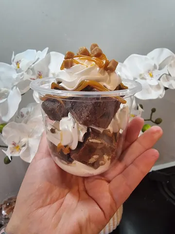 A hand holding a cup of food.