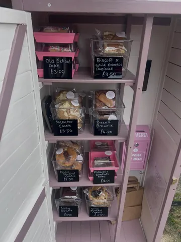 A pink shelf with a sign that says "Here!" on it.