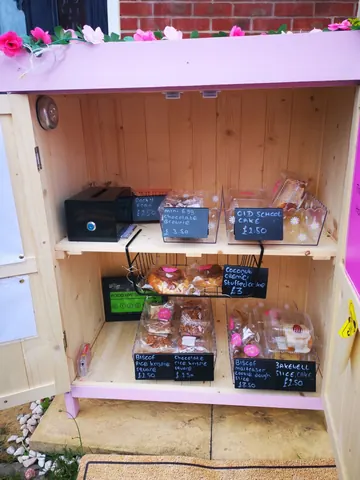 A wooden shelf with a sign that says "Baked goods" on it.