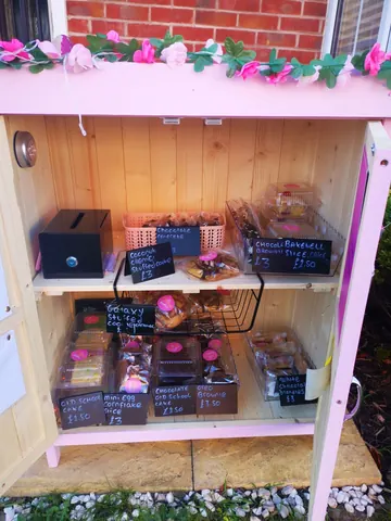 A wooden display case with a variety of pastries and desserts inside.
