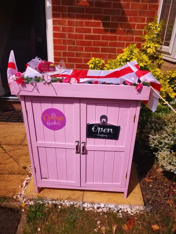 A pink and white box with a sign that says "open" on it.