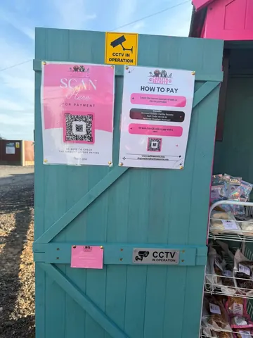 A blue shed with a sign on it that says "Scan Here".