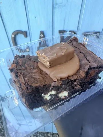 A chocolate cake with white frosting and chocolate chips.