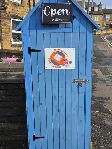 A blue shed with a sign on it.