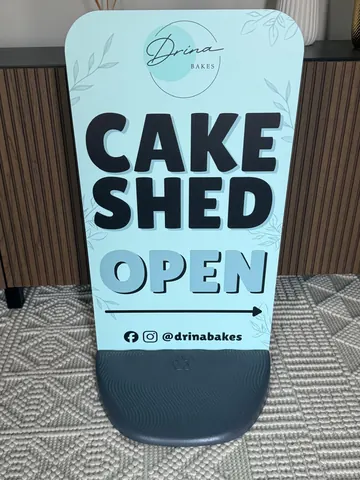 A sign that says "Cake Shed Open" is on the floor.