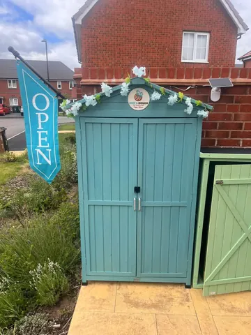 A blue shed with a sign that says open.
