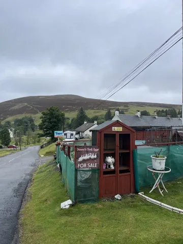A small wooden shed with a sign on it.