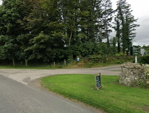 A sign is on a pole in a grassy area.