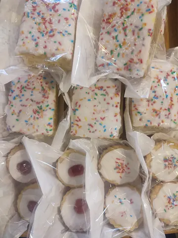 A box of cookies with sprinkles on top.