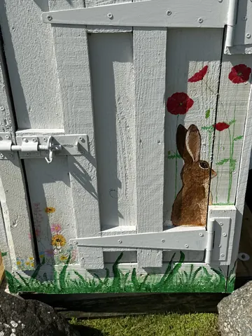 A white door with a rabbit painted on it.